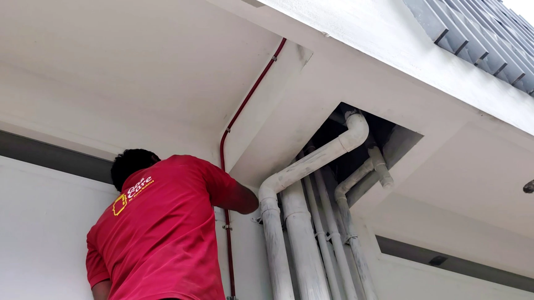 A snapshot shows a gas care by stove-technica expert drilling into the wall to connect a gas pipeline to the upstairs kitchen of an apartment building
