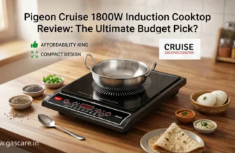 Review banner image for the Pigeon Cruise 1800W Induction Cooktop, titled "The Ultimate Budget Pick?". A stainless steel pot with steam sits on the detailed black cooktop on an acacia wood counter, surrounded by small bowls of spices, chopped cilantro, a folded chapati, and two idlis with chutney. Text callouts highlight pros with green thumbs-up: "AFFORDABILITY KING", "COMPACT DESIGN"; and a CRUICE induction cooktop logo, and text in the left bottom corner: www.gascare.in.